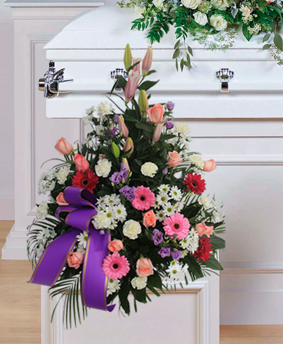Centro funerario en tonos rosa y lila con lazo morado