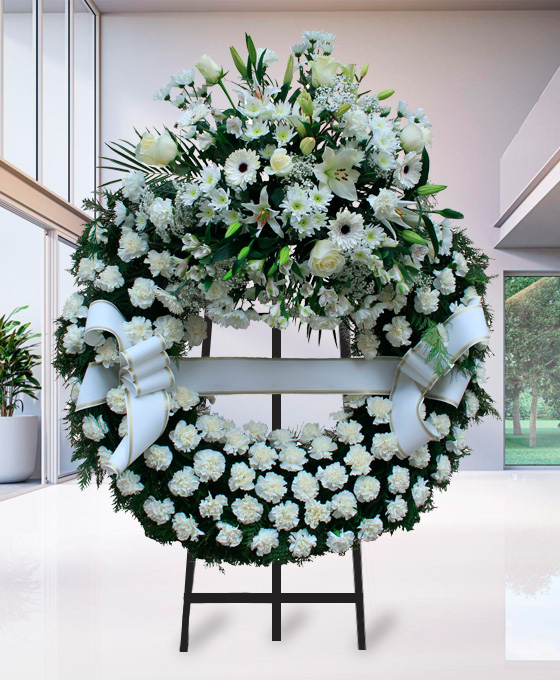 Corona funeraria de clavel blanco con centro decorado y lazo blanco